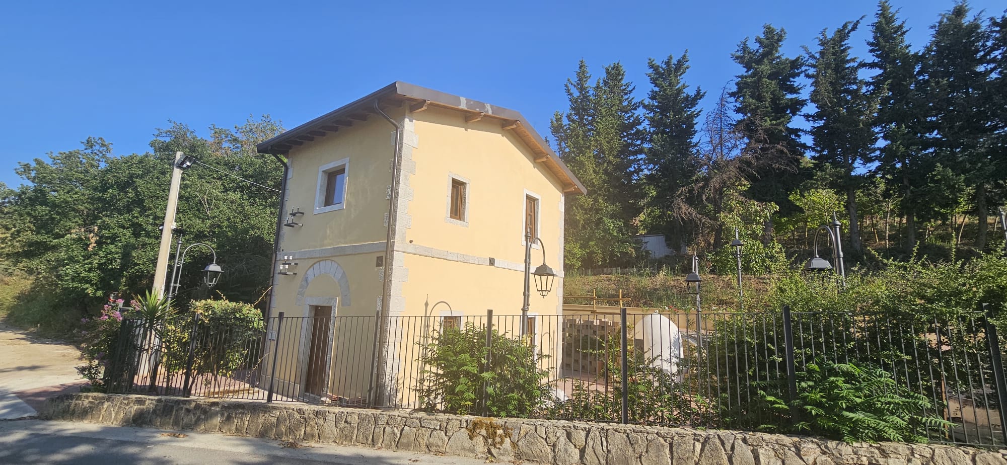 La facciata restaurata del casello con il giardino e la vista sulla campagna di Corleone