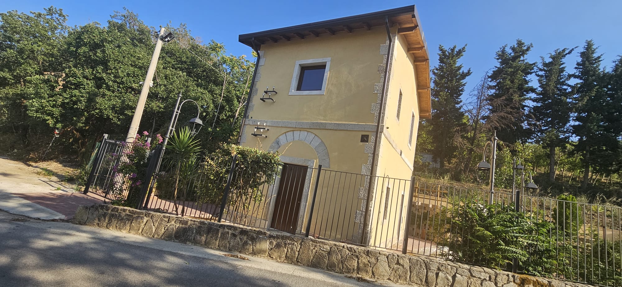 Il Casello San Calogero restaurato, visto dalla strada con il cancello e il giardino terrazzato
