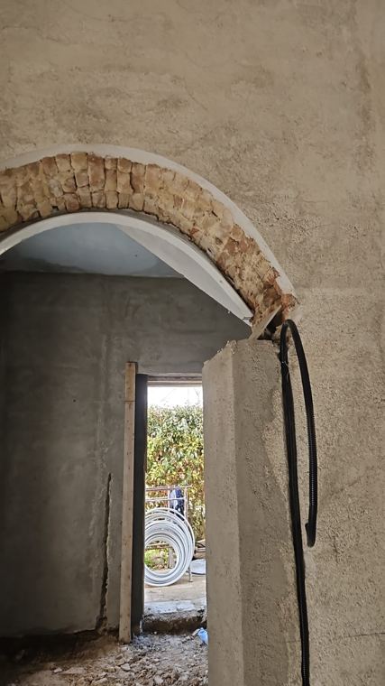 Arco interno in pietra e mattoni riportato a vista tra gli ambienti