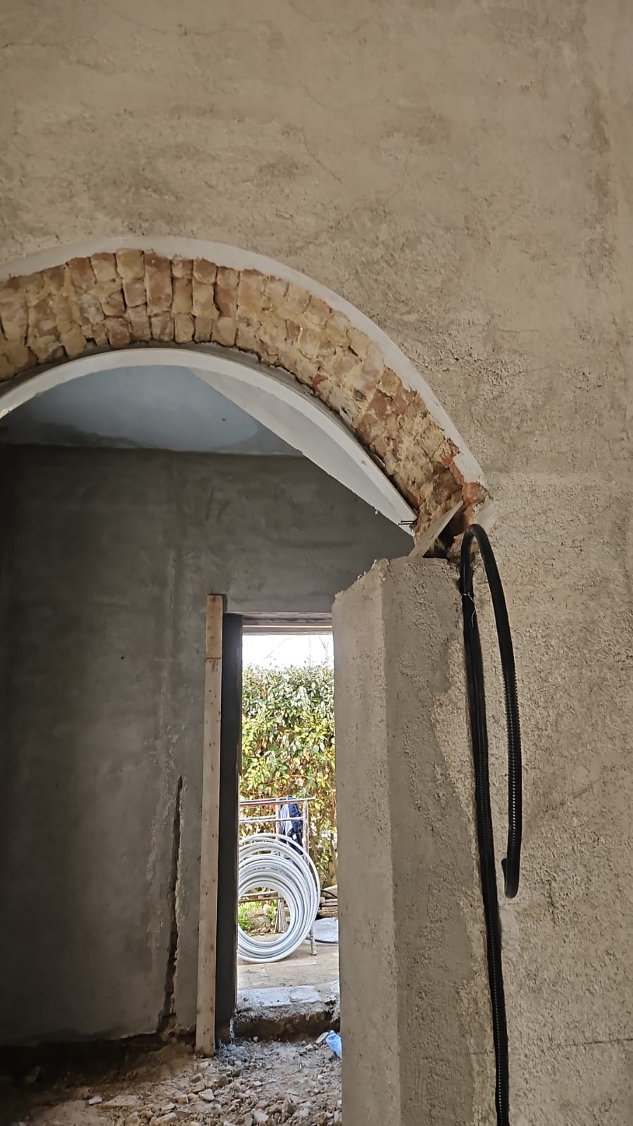 Arco interno in pietra e mattoni riportato a vista tra gli ambienti
