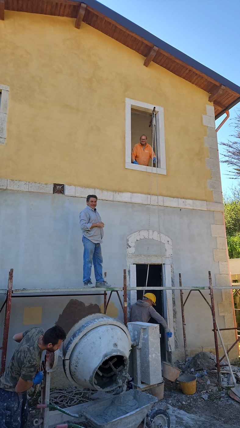 Il casello in cantiere: ponteggio, betoniera e maestranze al lavoro sulla facciata