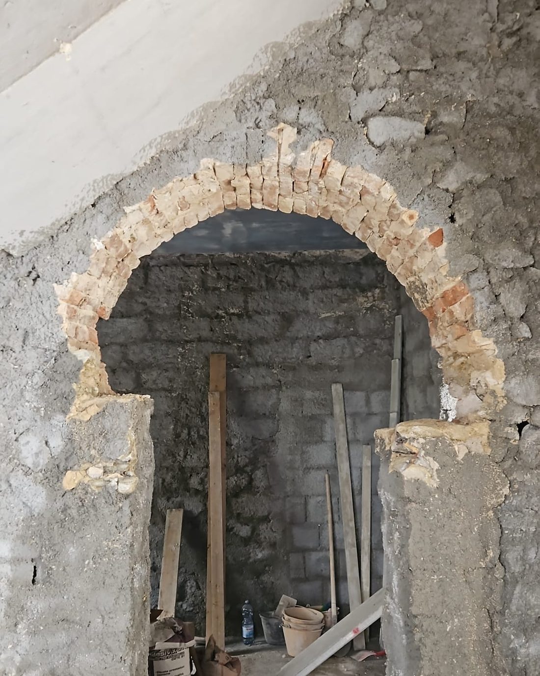 Lo spigolo del casello con i conci di pietra calcarea a vista, il contorno in pietra della finestra e l'arco